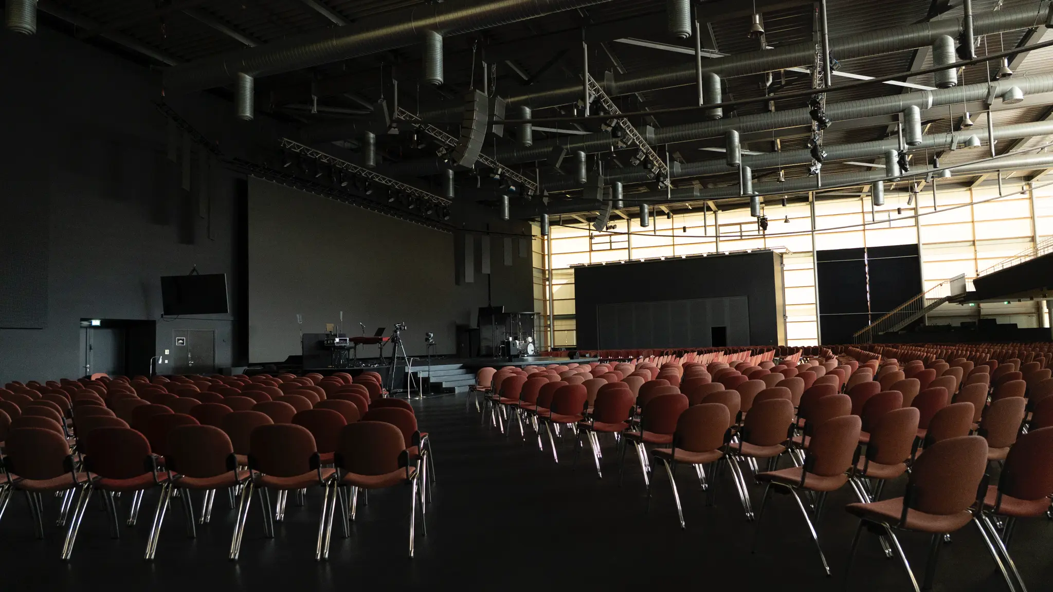 Großer Saal aus seitlicher Perspektive mit dunklem Boden