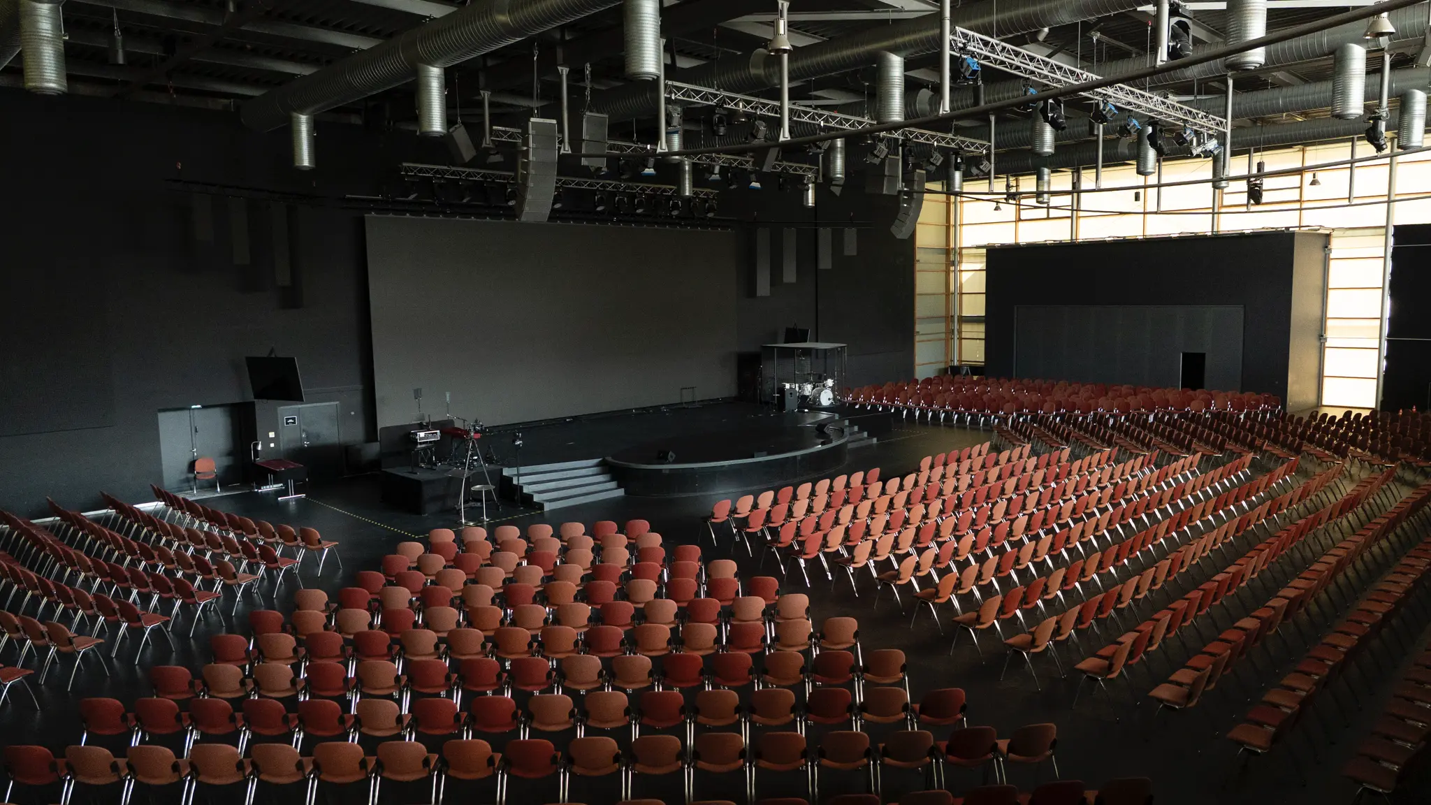 Großer Saal mit Bestuhlung und dunklem Boden